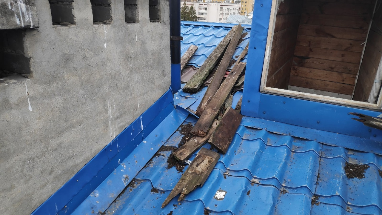 На одной из покатых крыш домов в Йошкар-Оле лежат большие гнилые доски